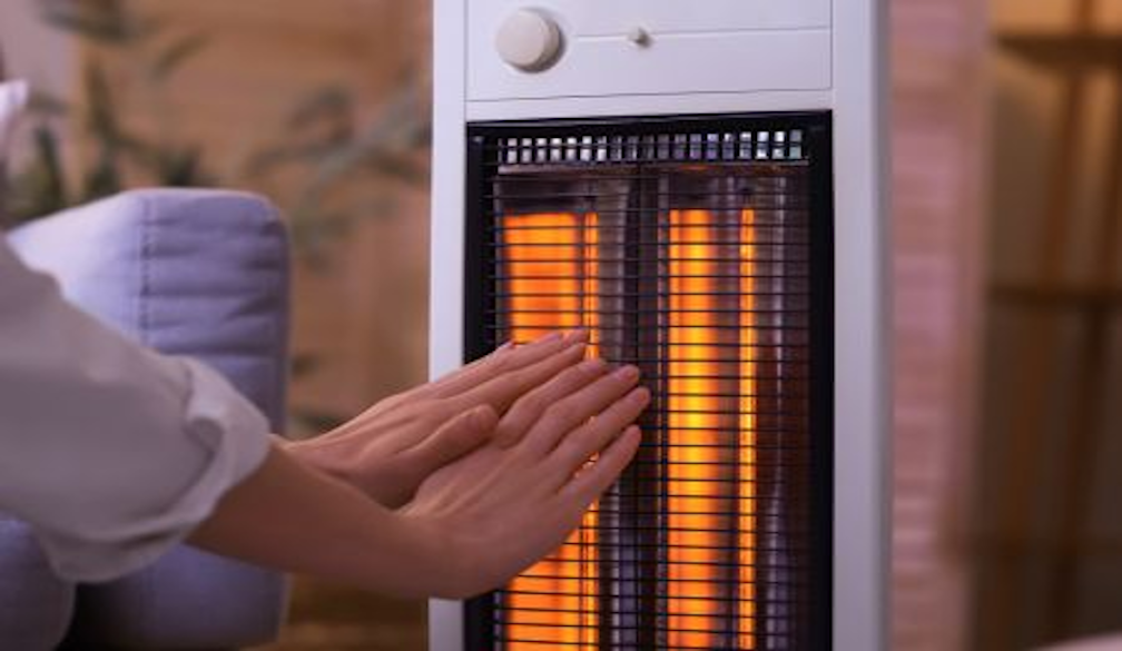 Person heating their hands at an electric heater