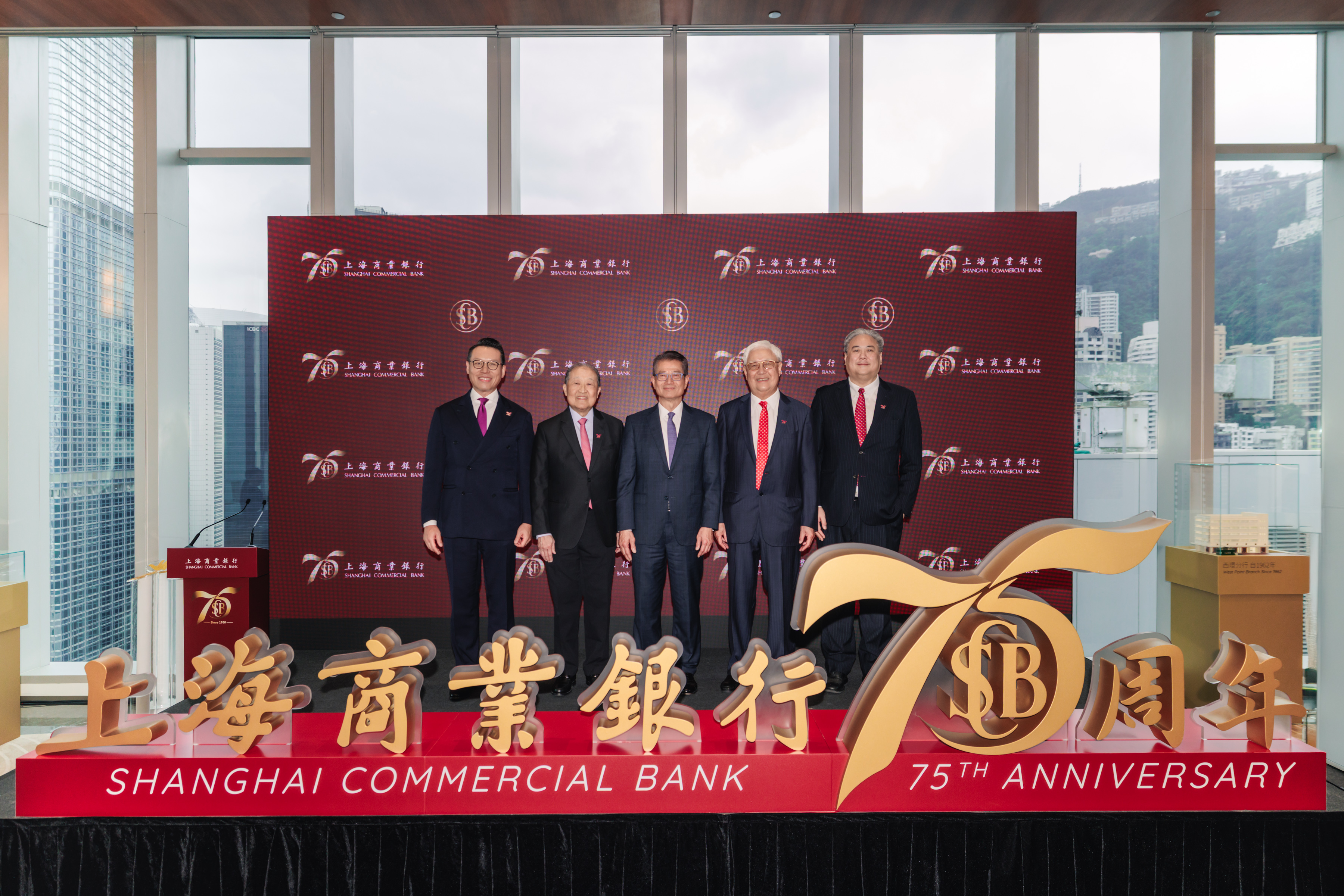 Officiating at the kick-off ceremony for Shanghai Commercial Bank’s 75th anniversary celebrations are: The Honourable Paul CHAN Mo-po, GBM, GBS, MH, JP, Financial Secretary of the Hong Kong SAR Government (Middle); Mr. Stephen LEE Ching-yen, Chairman of Shanghai Commercial Bank (Second Left); Mr. Lincoln YUNG Chu-kuen, JP, Director of The Shanghai Commercial & Savings Bank (Second Right); Mr. John YUNG Con-sing, Non-executive Director of Shanghai Commercial Bank (First Right); and Mr. Wallace LAM Wing-ted, Chief Executive of Shanghai Commercial Bank (First Left).